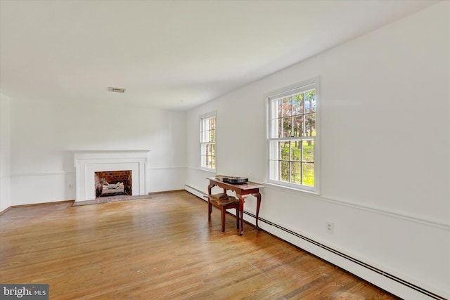 444 Rocksville Rd, Holland, PA 18966 - living area with a baseboard heating unit, wood finished floors, a fireplace, and baseboards