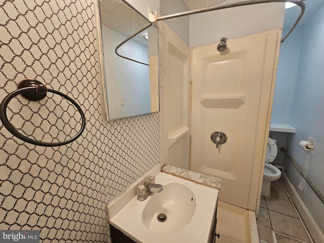 full bath featuring toilet, tile patterned flooring, a shower, and vanity