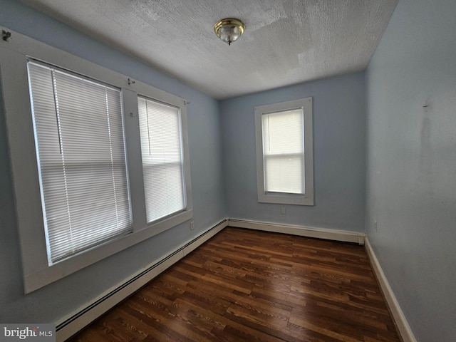 empty room with a baseboard radiator, a textured ceiling, baseboards, and wood finished floors