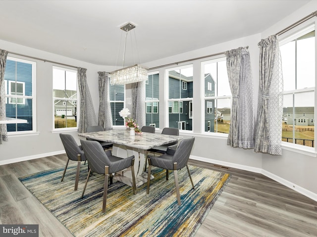 dining area with visible vents, baseboards, and wood finished floors