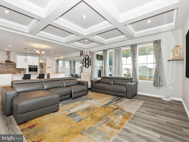 living room featuring a wealth of natural light, baseboards, an inviting chandelier, and wood finished floors