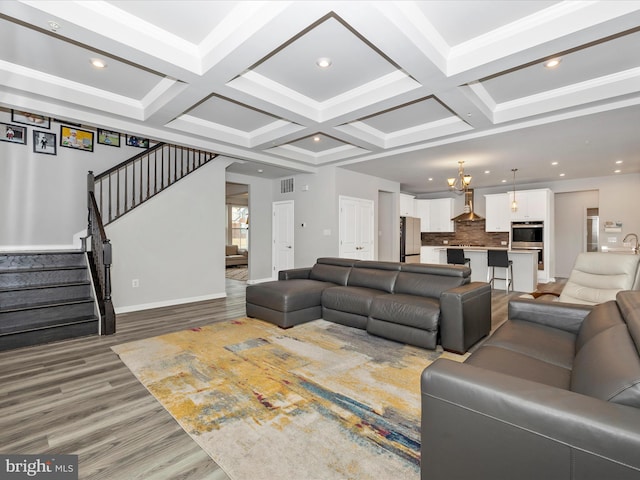 living area featuring beam ceiling, stairway, and coffered ceiling