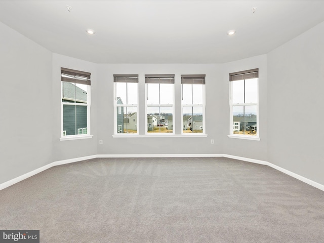 carpeted spare room featuring recessed lighting, a healthy amount of sunlight, and baseboards