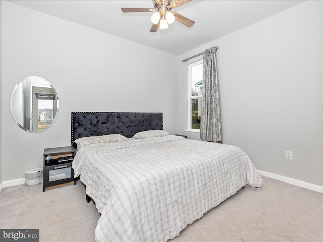 bedroom with ceiling fan, baseboards, and light carpet