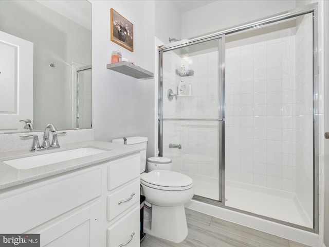 bathroom with vanity, toilet, and a stall shower