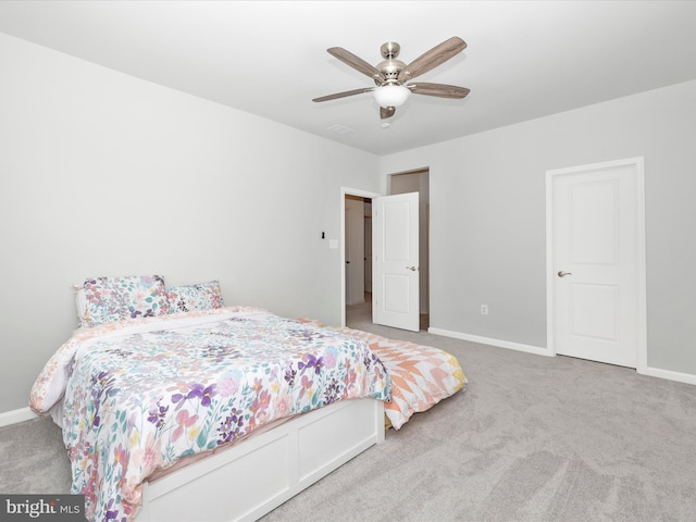 carpeted bedroom with ceiling fan and baseboards