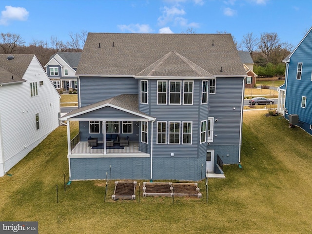 back of house featuring a patio, cooling unit, a lawn, and a shingled roof