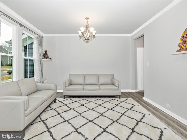 living area featuring ornamental molding, wood finished floors, baseboards, and a chandelier