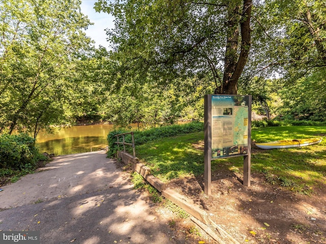 view of property's community with a yard and a water view