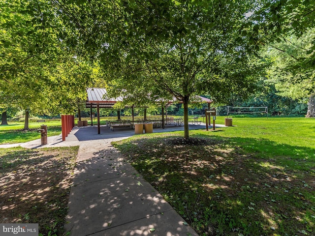 view of community with volleyball court and a lawn