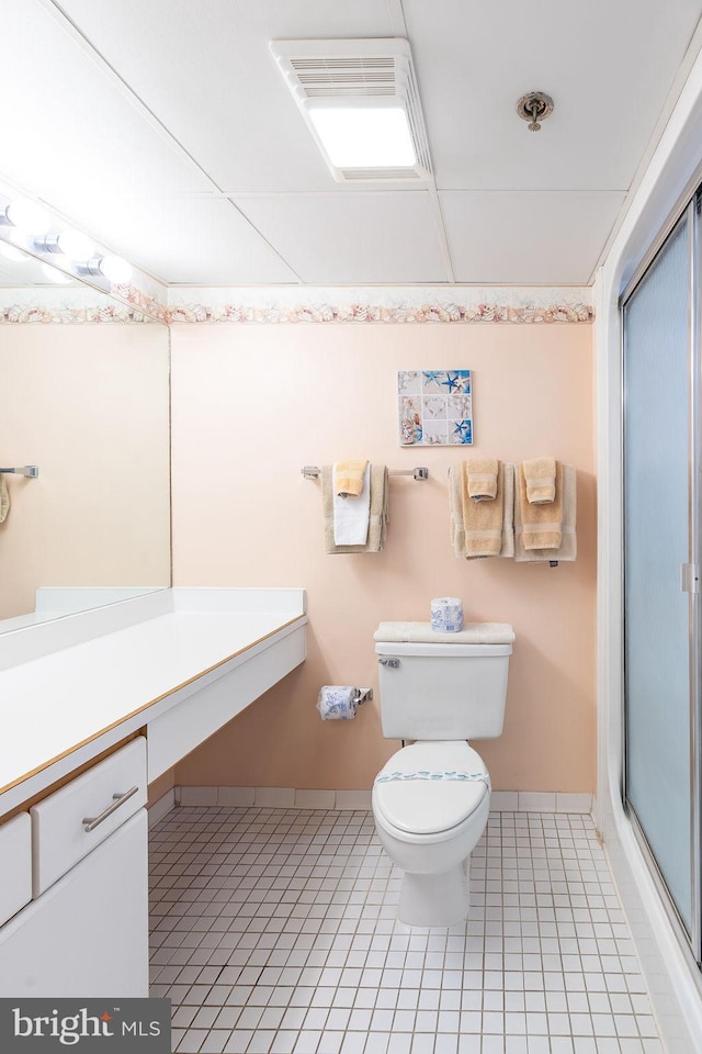 full bathroom featuring baseboards, toilet, a shower with door, tile patterned floors, and vanity