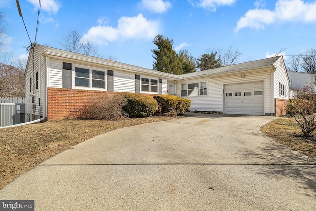 single story home with brick siding, fence, concrete driveway, cooling unit, and an attached garage