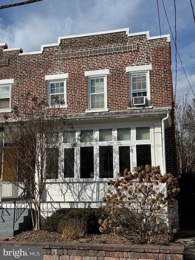 exterior space with cooling unit and brick siding