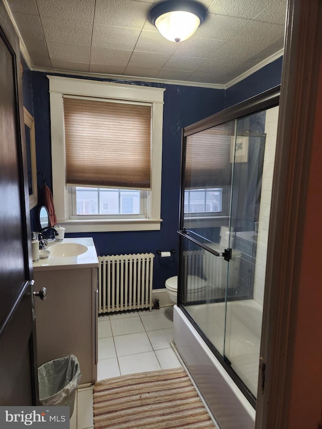 bathroom with radiator, toilet, tile patterned floors, crown molding, and vanity