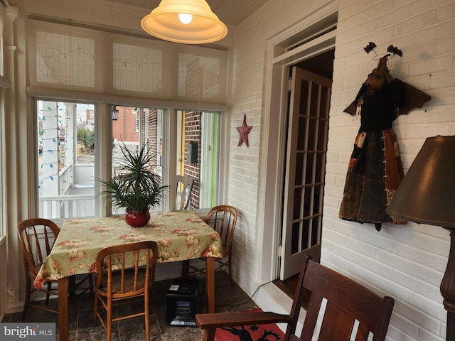 dining area featuring brick wall