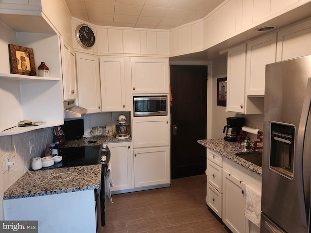 kitchen with appliances with stainless steel finishes, stone counters, exhaust hood, and white cabinets