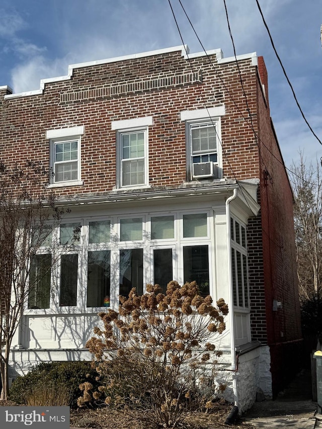 view of side of home featuring cooling unit and brick siding