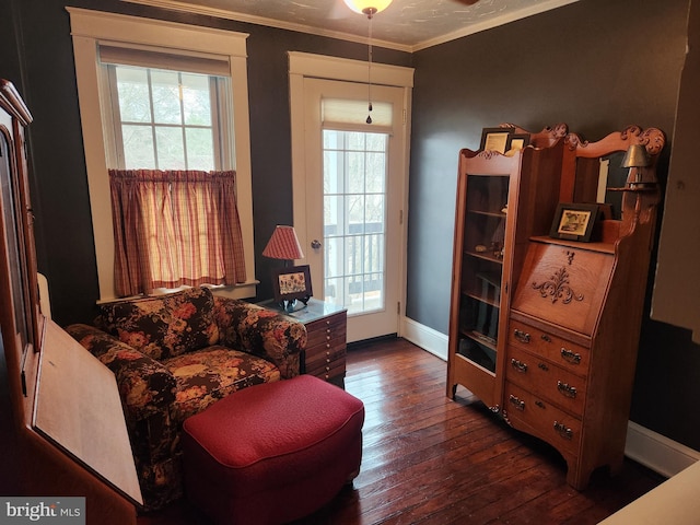 sitting room featuring a wealth of natural light, baseboards, dark wood-style floors, and crown molding