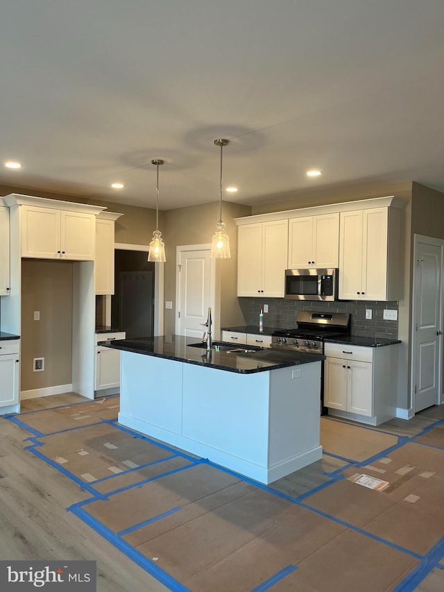 kitchen with appliances with stainless steel finishes, a sink, and white cabinets