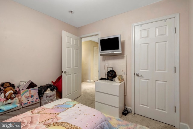 bedroom with light carpet and baseboards