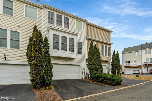 multi unit property featuring an attached garage and driveway