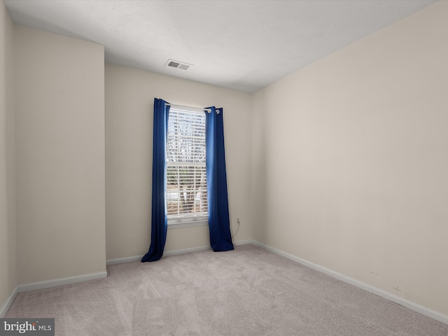 carpeted empty room with visible vents and baseboards