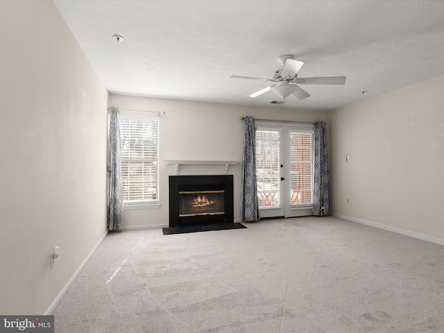 unfurnished living room featuring baseboards, a healthy amount of sunlight, and carpet flooring