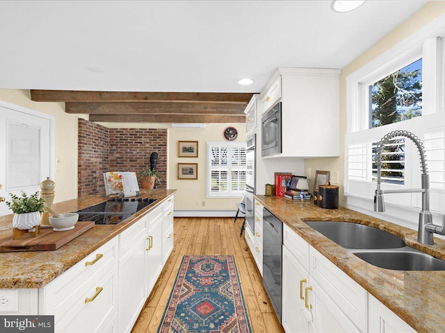 kitchen with white cabinets, light wood-style flooring, beamed ceiling, stainless steel appliances, and a sink