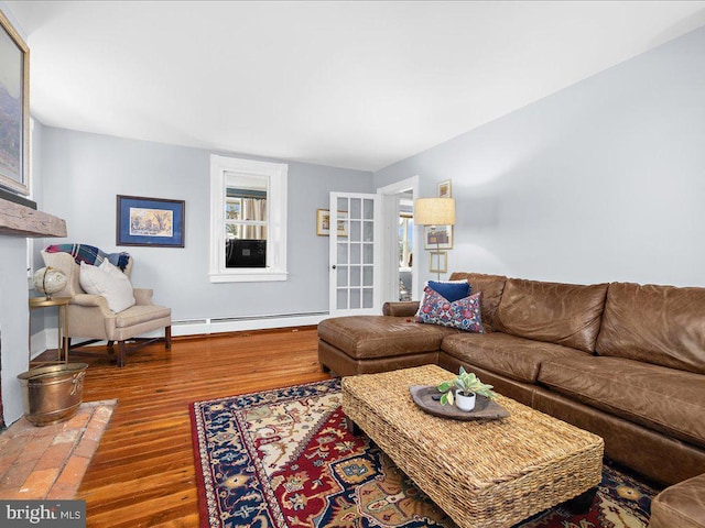 living room with a baseboard heating unit and wood finished floors