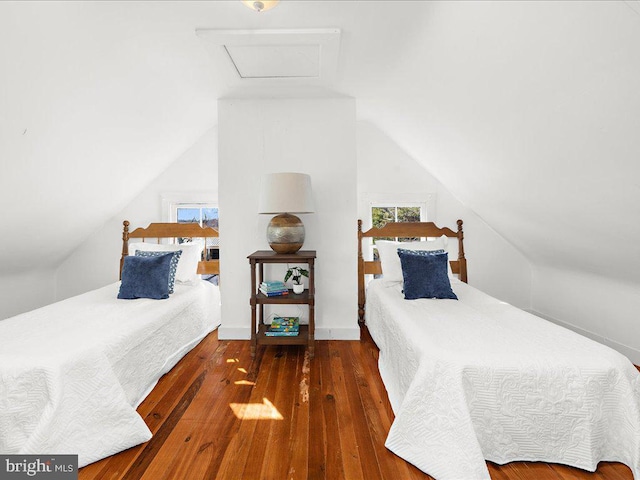 bedroom with vaulted ceiling, hardwood / wood-style flooring, and attic access