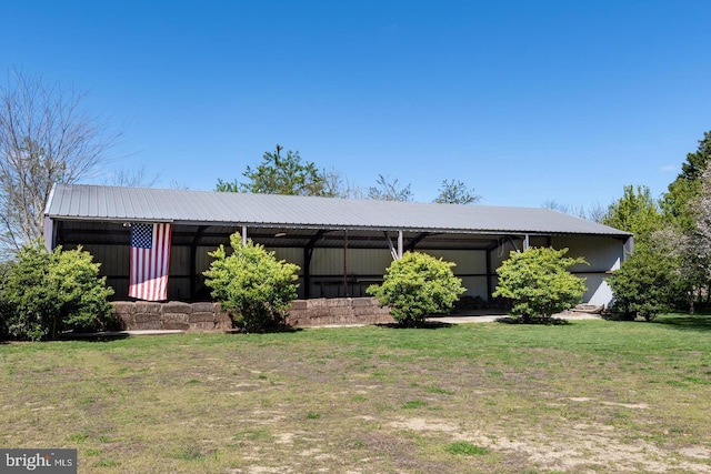 mid-century modern home featuring an outbuilding, metal roof, and a front yard