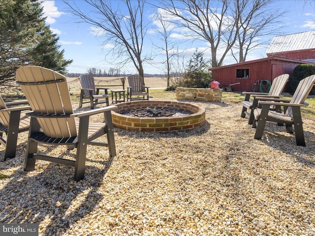 view of yard with a fire pit and an outbuilding