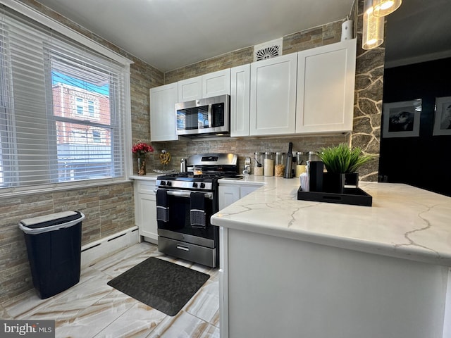 kitchen with stainless steel appliances, a baseboard radiator, white cabinetry, and light stone countertops