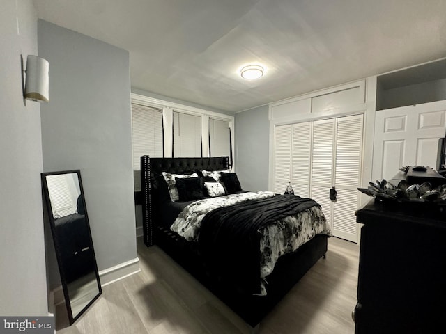 bedroom featuring a closet, baseboards, and wood finished floors