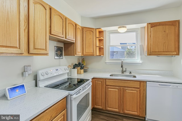 kitchen featuring white appliances, light countertops, and a sink