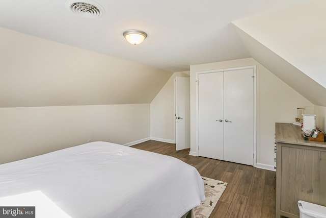 bedroom featuring vaulted ceiling, visible vents, baseboards, and dark wood-style flooring