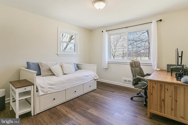 office space featuring dark wood-style floors, visible vents, baseboards, and a wealth of natural light