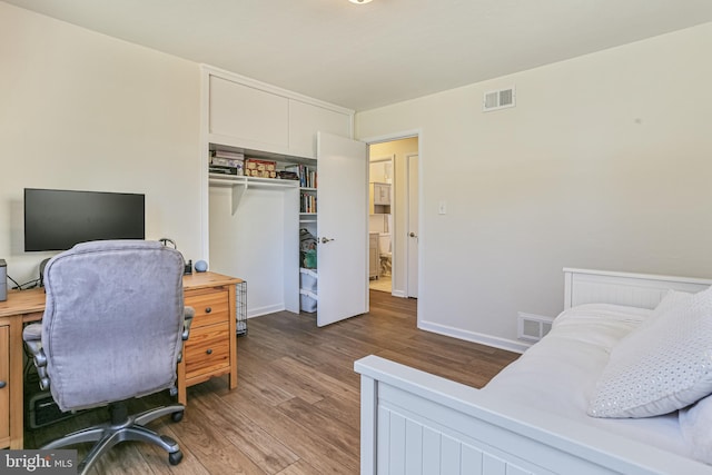 bedroom featuring a closet, visible vents, and wood finished floors