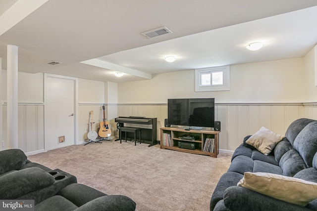 carpeted living area with visible vents and wainscoting