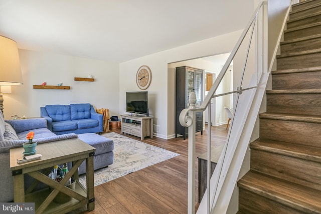 living area with stairs, dark wood finished floors, and baseboards