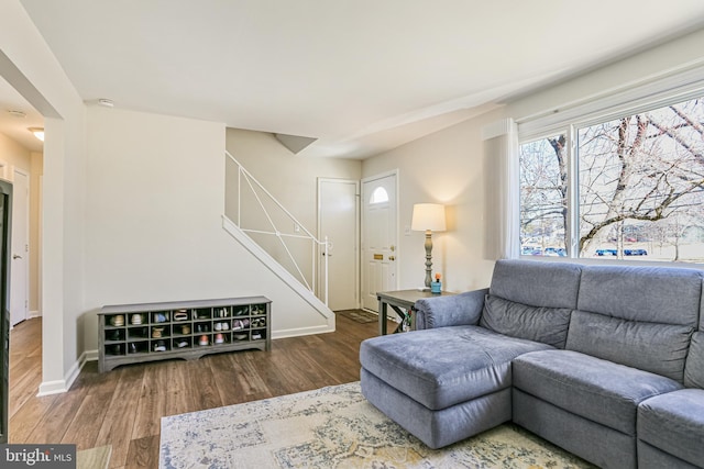 living area with stairs, wood finished floors, and baseboards