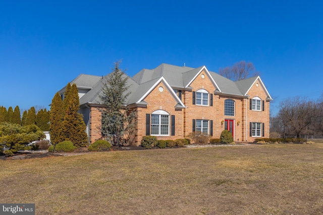 view of front facade with a front lawn and brick siding