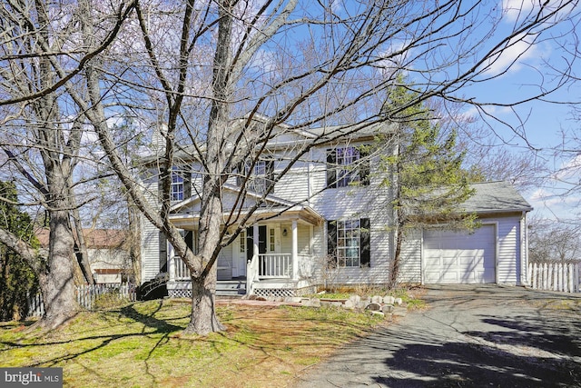 view of front of house with a garage, aphalt driveway, a porch, and fence