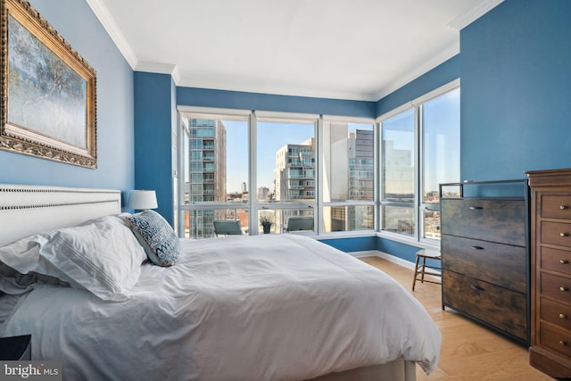 bedroom with a view of city, ornamental molding, light wood-style flooring, and baseboards