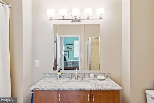 ensuite bathroom featuring toilet, a shower stall, vanity, and ensuite bathroom