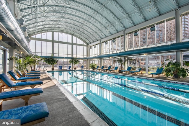 pool with a patio area and glass enclosure