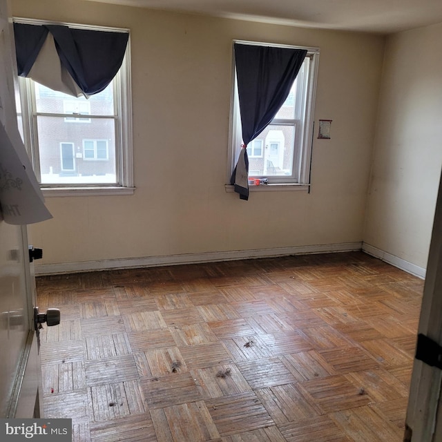 unfurnished room featuring baseboards