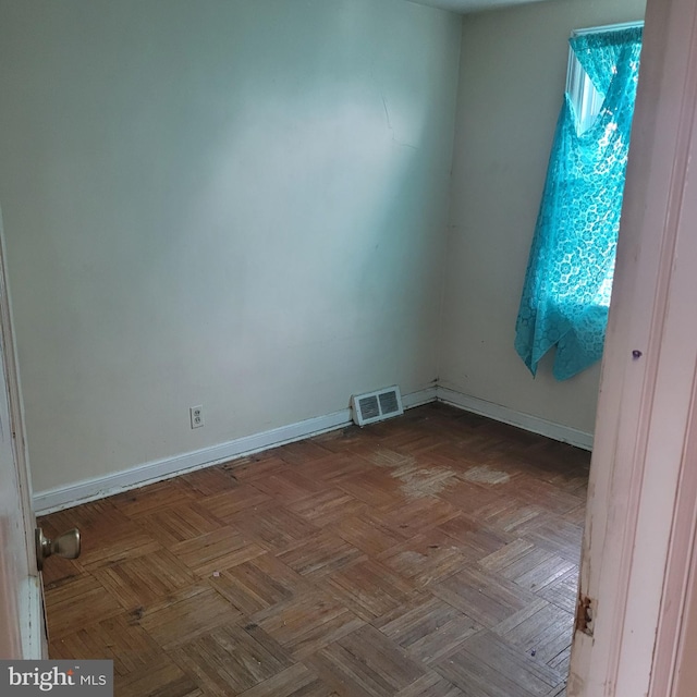 unfurnished room with baseboards and visible vents