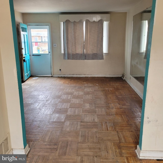 empty room featuring baseboards and visible vents