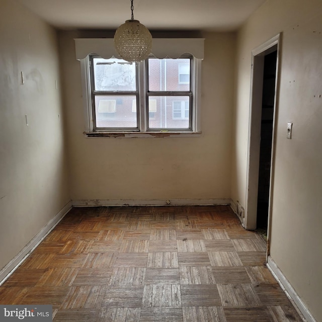 unfurnished room with baseboards